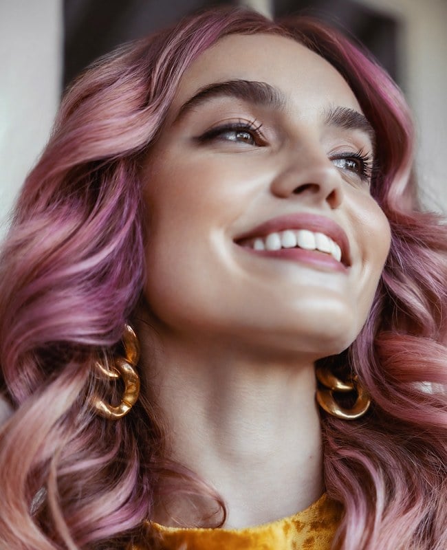 Woman with curly hair and purple hair color
