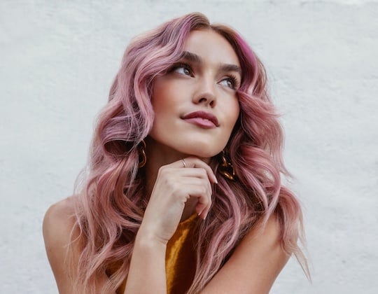 Woman with wavy, pink colored hair