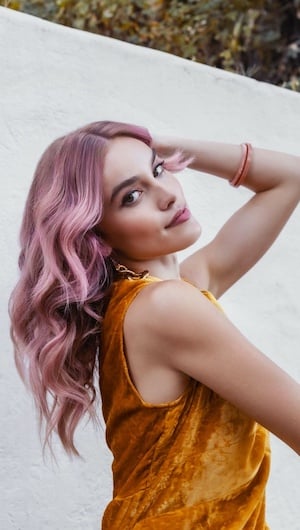 Woman with curly hair and pink hair color