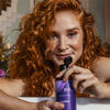 Woman with red curly hair holding her personalized Aura conditioner thumbnail
