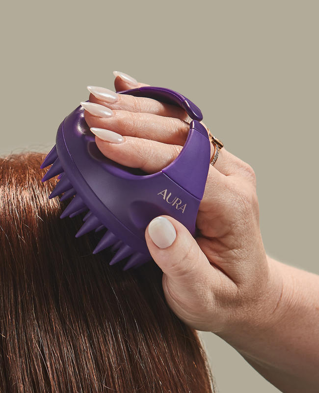 Scalp massager held in a woman's hand